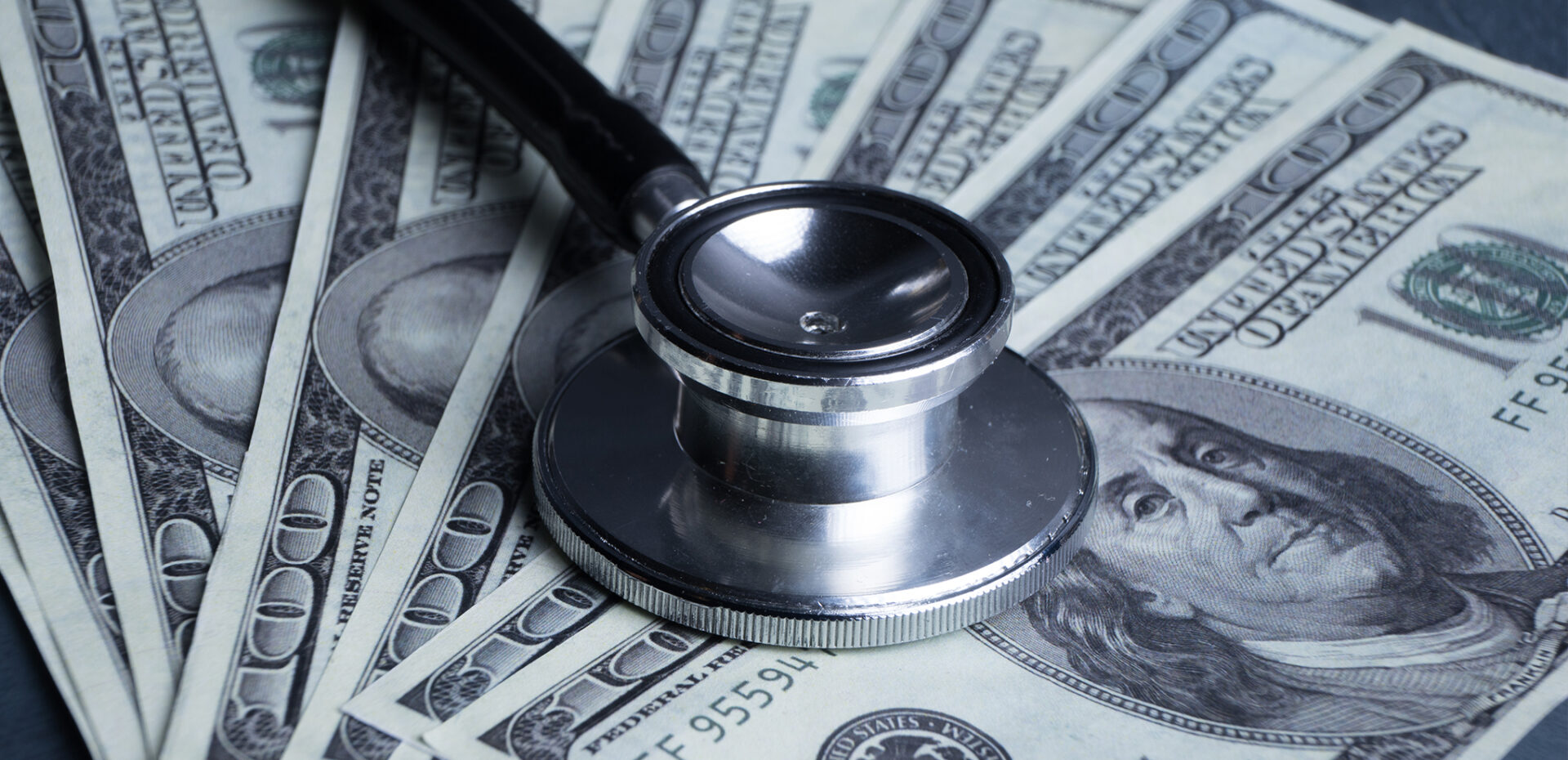 Stethoscope on a pile of $100 bills