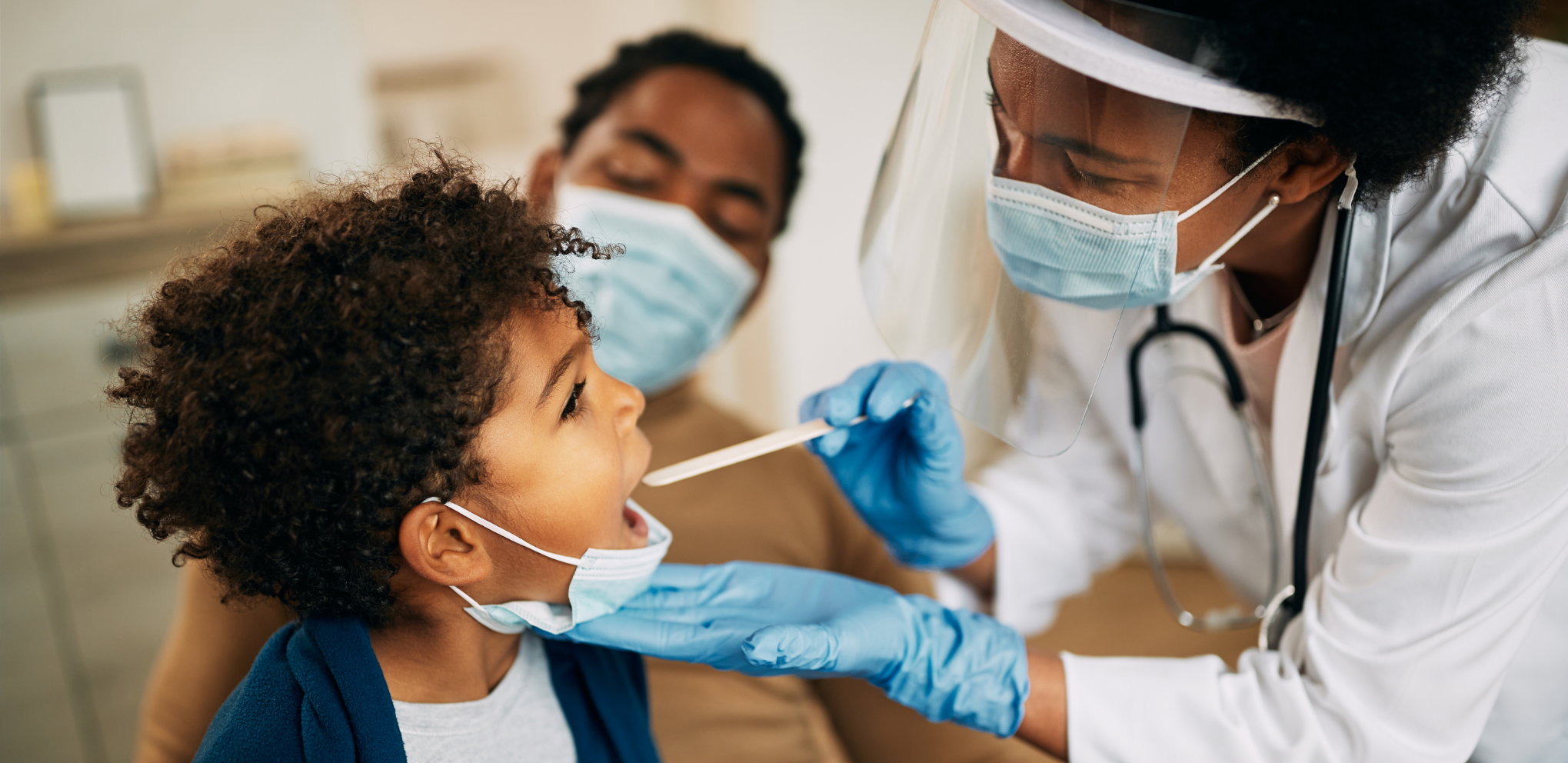 Masked doctor doing a checkup on a toddler