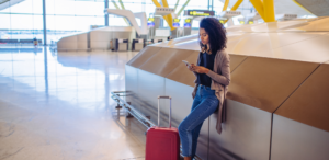 person at airport leaning against baggage carousel